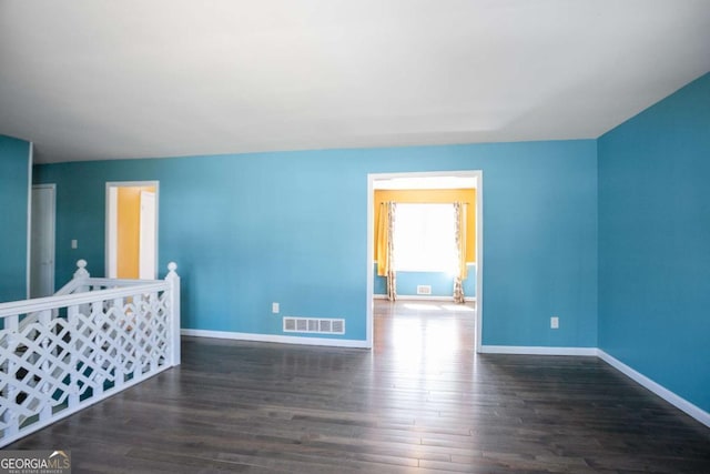 unfurnished room featuring visible vents, baseboards, and wood finished floors