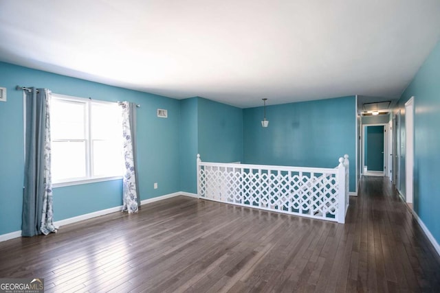 unfurnished room featuring baseboards and hardwood / wood-style floors