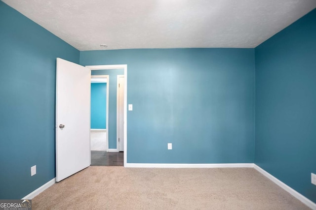 empty room with carpet and baseboards