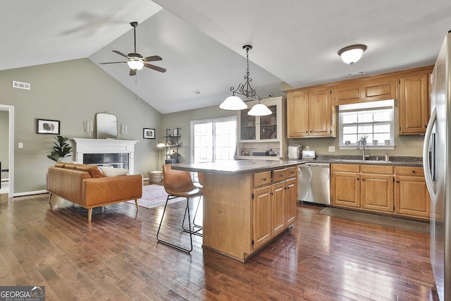 kitchen featuring a sink, stainless steel appliances, dark countertops, and visible vents