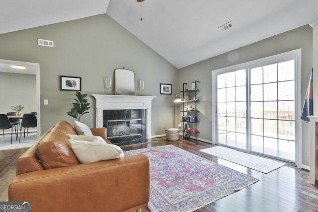 living room featuring wood finished floors, a fireplace, visible vents, and ceiling fan