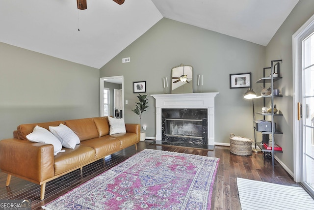 living area featuring wood finished floors, lofted ceiling, ceiling fan, and a fireplace