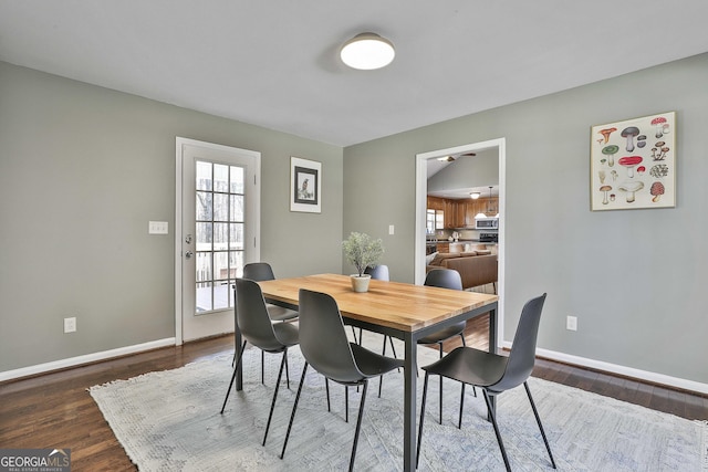 dining area with ceiling fan, baseboards, and dark wood-style floors