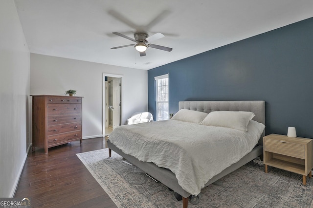 bedroom featuring baseboards, dark wood finished floors, and a ceiling fan