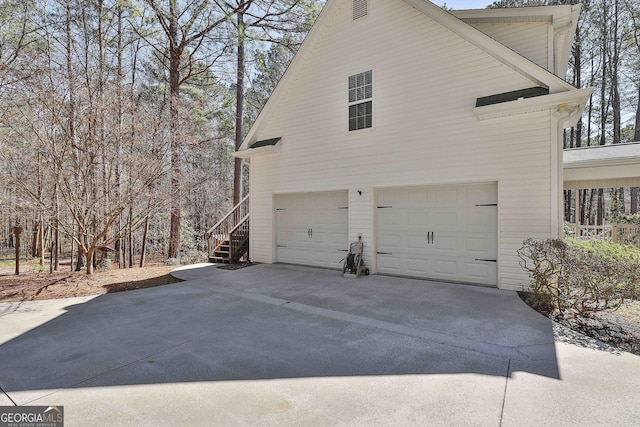 view of side of home featuring concrete driveway and an attached garage