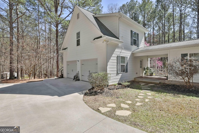 view of side of property featuring an attached garage, a shingled roof, and driveway