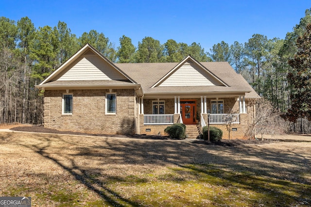 view of front facade with covered porch, brick siding, crawl space, and a shingled roof