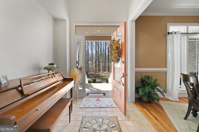 foyer entrance featuring ornamental molding and wood finished floors