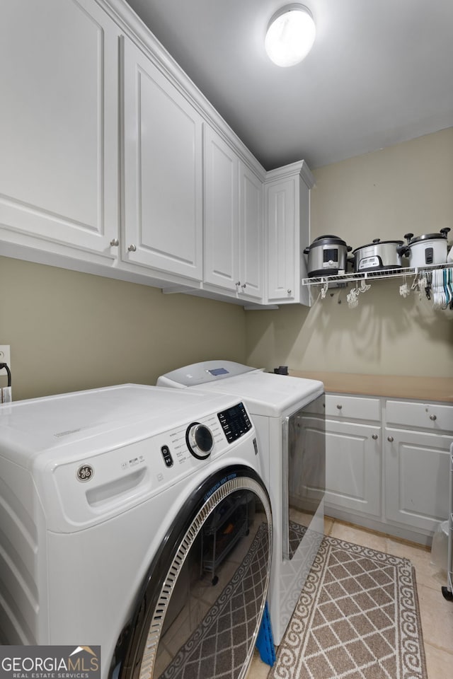 laundry area featuring cabinet space, independent washer and dryer, and light tile patterned flooring