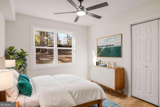 bedroom featuring light wood-type flooring, ceiling fan, and a closet