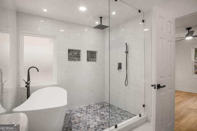 full bathroom featuring a marble finish shower, recessed lighting, ceiling fan, wood finished floors, and a freestanding tub