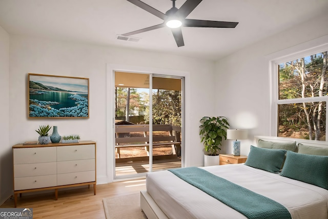 bedroom featuring access to exterior, multiple windows, visible vents, and light wood-style floors