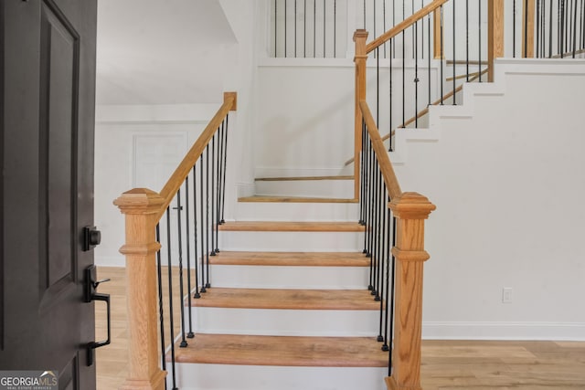 staircase featuring baseboards and wood finished floors