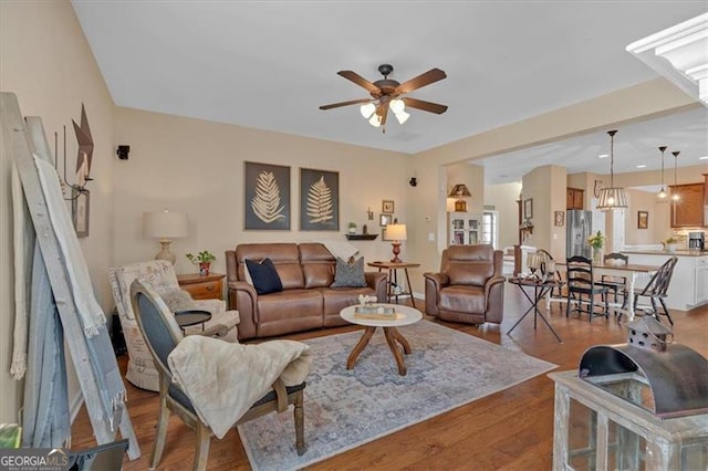 living area with ceiling fan and wood finished floors