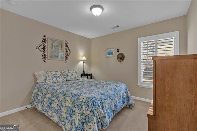 carpeted bedroom featuring visible vents and baseboards