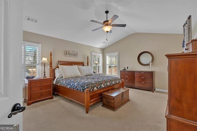 bedroom with light carpet, multiple windows, lofted ceiling, and visible vents