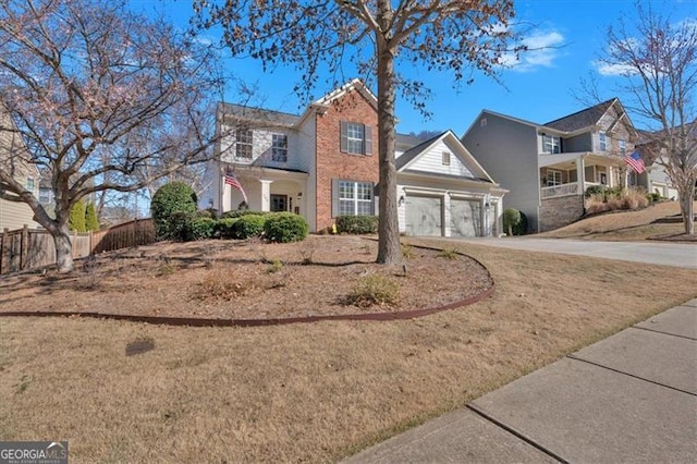 view of front facade with a garage, driveway, brick siding, and fence