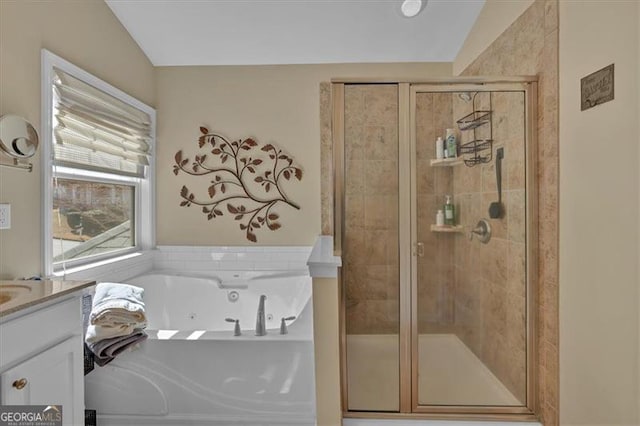 bathroom with a stall shower, a jetted tub, and vanity