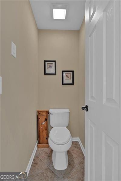 bathroom featuring baseboards, toilet, and tile patterned floors