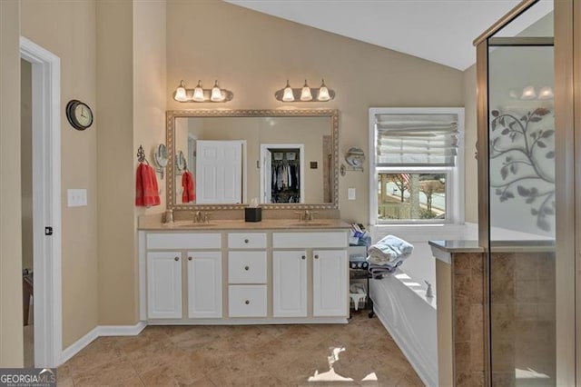 full bath featuring lofted ceiling, a garden tub, double vanity, and a sink