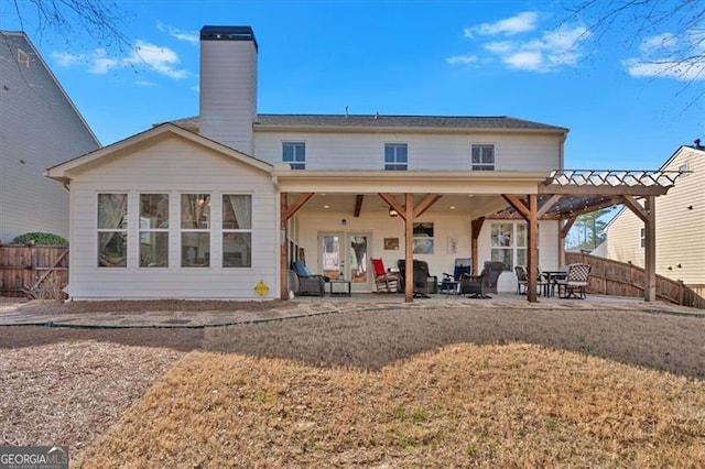 back of house with a patio, fence, a yard, french doors, and a chimney