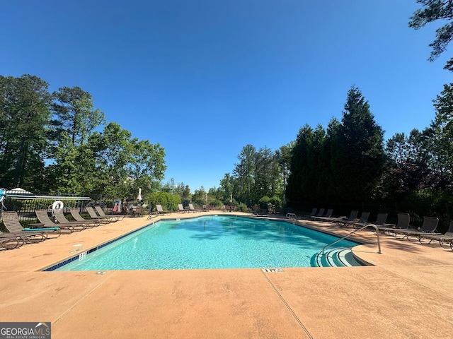 community pool with fence and a patio