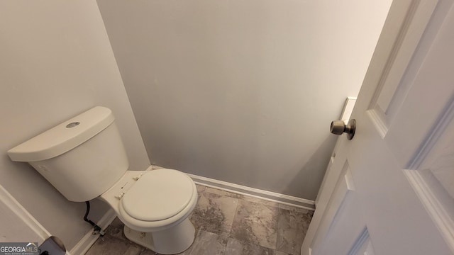 bathroom with toilet and baseboards