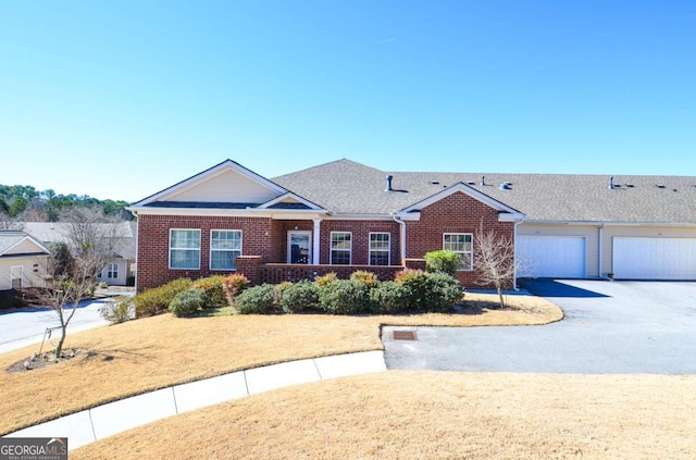 ranch-style home with aphalt driveway, a front yard, and brick siding