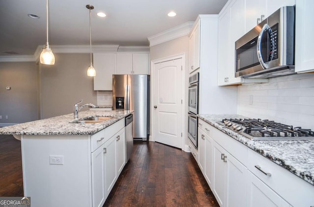 kitchen featuring appliances with stainless steel finishes, white cabinets, a sink, and ornamental molding