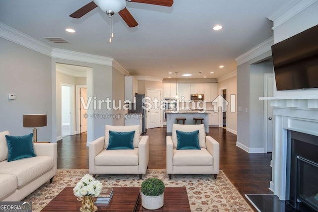 living room featuring crown molding, a fireplace, visible vents, and dark wood-type flooring