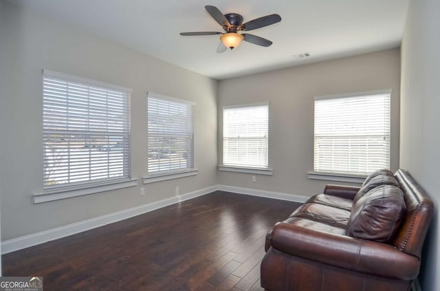 sitting room featuring visible vents, ceiling fan, baseboards, and wood finished floors