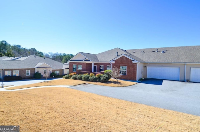 ranch-style home with a garage, driveway, and brick siding