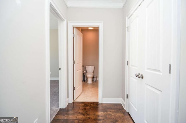 hall featuring baseboards, ornamental molding, and wood finished floors