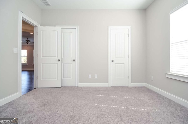 unfurnished bedroom featuring carpet flooring, visible vents, and baseboards