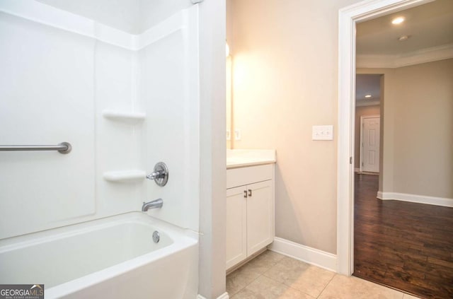 full bathroom with crown molding, vanity, shower / tub combination, baseboards, and tile patterned floors