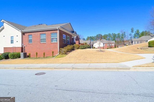 view of side of property featuring a yard and brick siding