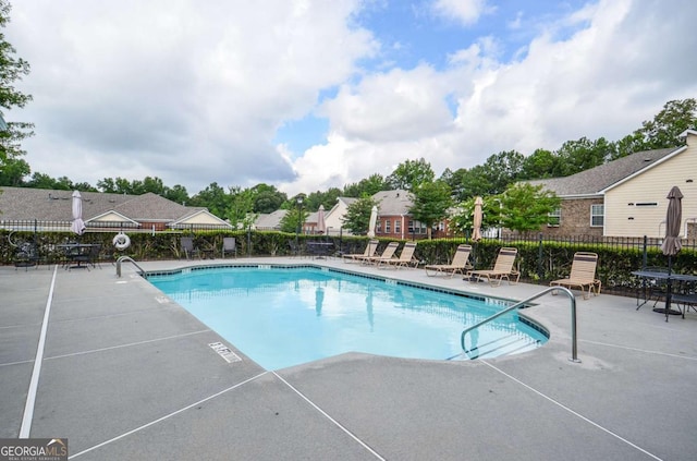 community pool featuring a patio area and fence