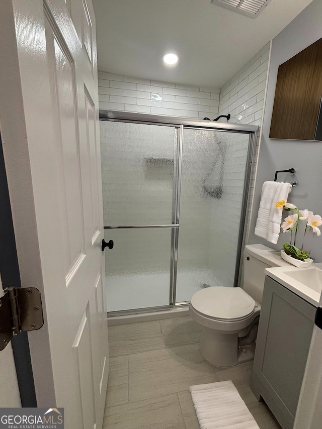 bathroom featuring a stall shower, visible vents, toilet, vanity, and recessed lighting