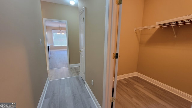 hall with baseboards and wood finished floors