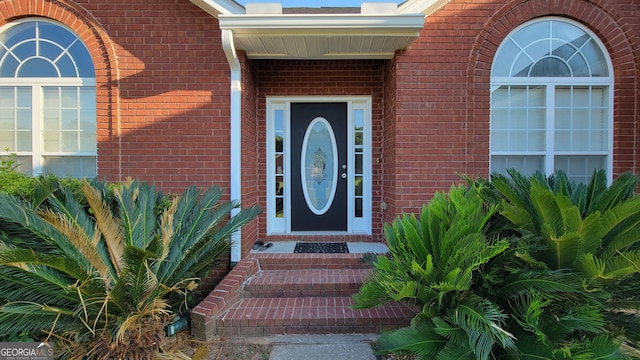 doorway to property with brick siding