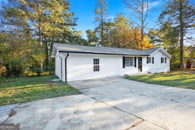 view of front of property with concrete driveway, a front yard, and fence