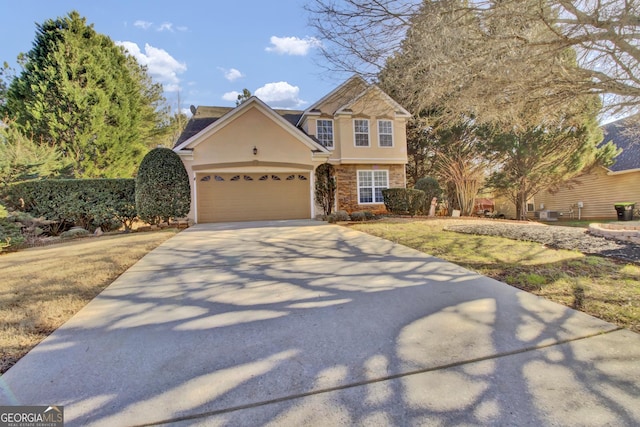 view of front facade with concrete driveway, an attached garage, and stucco siding