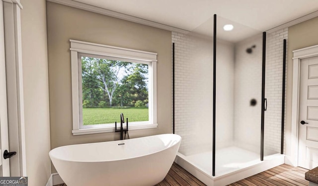 full bath featuring a stall shower, a freestanding tub, and wood finished floors