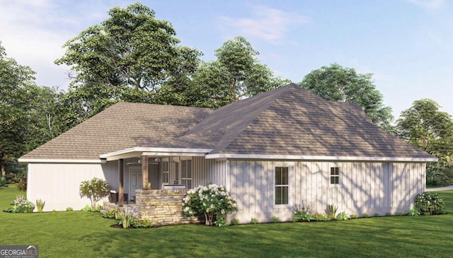 view of front of house with roof with shingles and a front yard