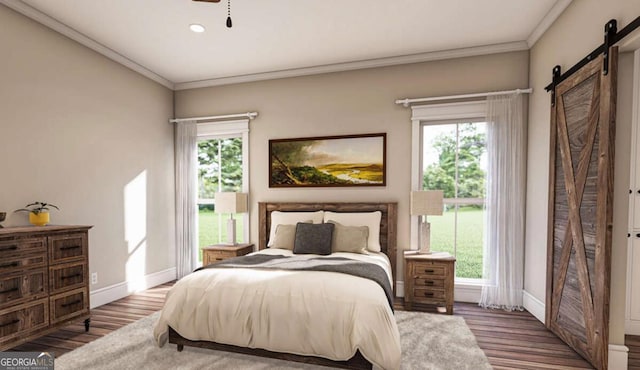 bedroom with wood finished floors, crown molding, baseboards, and a barn door