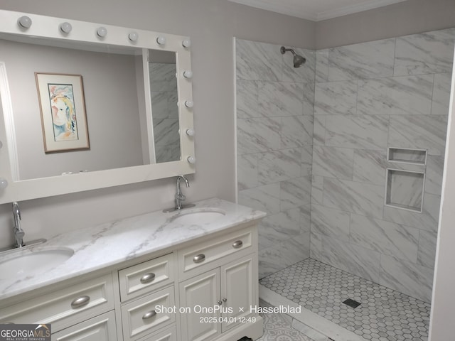 full bathroom with a tile shower, crown molding, double vanity, and a sink
