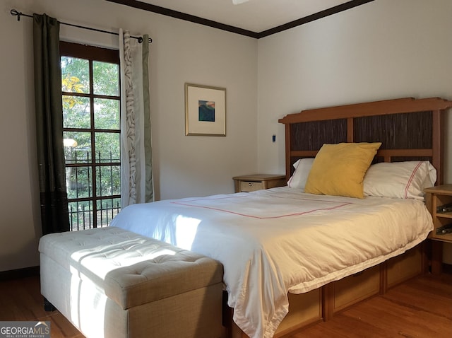 bedroom with crown molding and wood finished floors