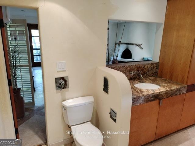 half bath featuring vanity and toilet