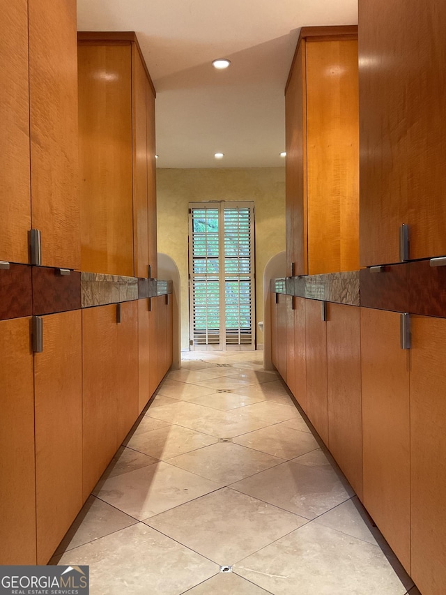 hall featuring light tile patterned floors and recessed lighting