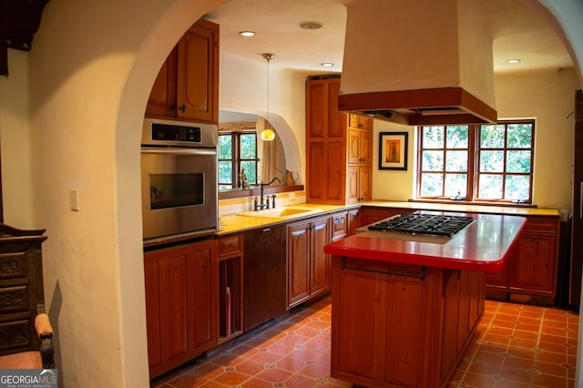 kitchen with a center island, a sink, light countertops, appliances with stainless steel finishes, and island exhaust hood